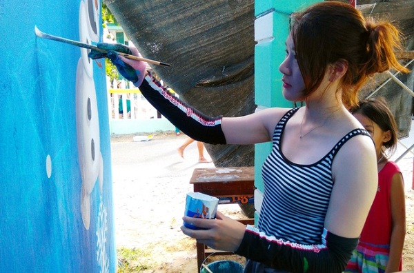 Đám trẻ làng chài thích thú xem họa sĩ xinh đẹp 25 tuổi Oh Ye Seul vẽ tranh trên tường nhà